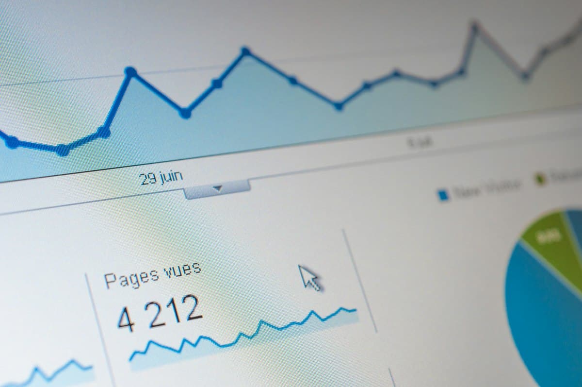 Layar komputer menampilkan grafik dan data analitik traffic berwarna biru.