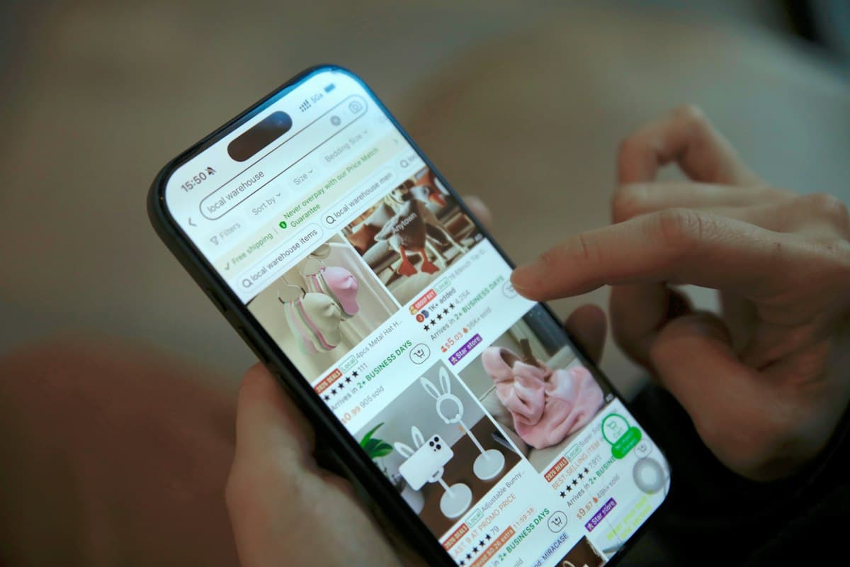 Seseorang menggeser layar ponsel sambil berbelanja online.