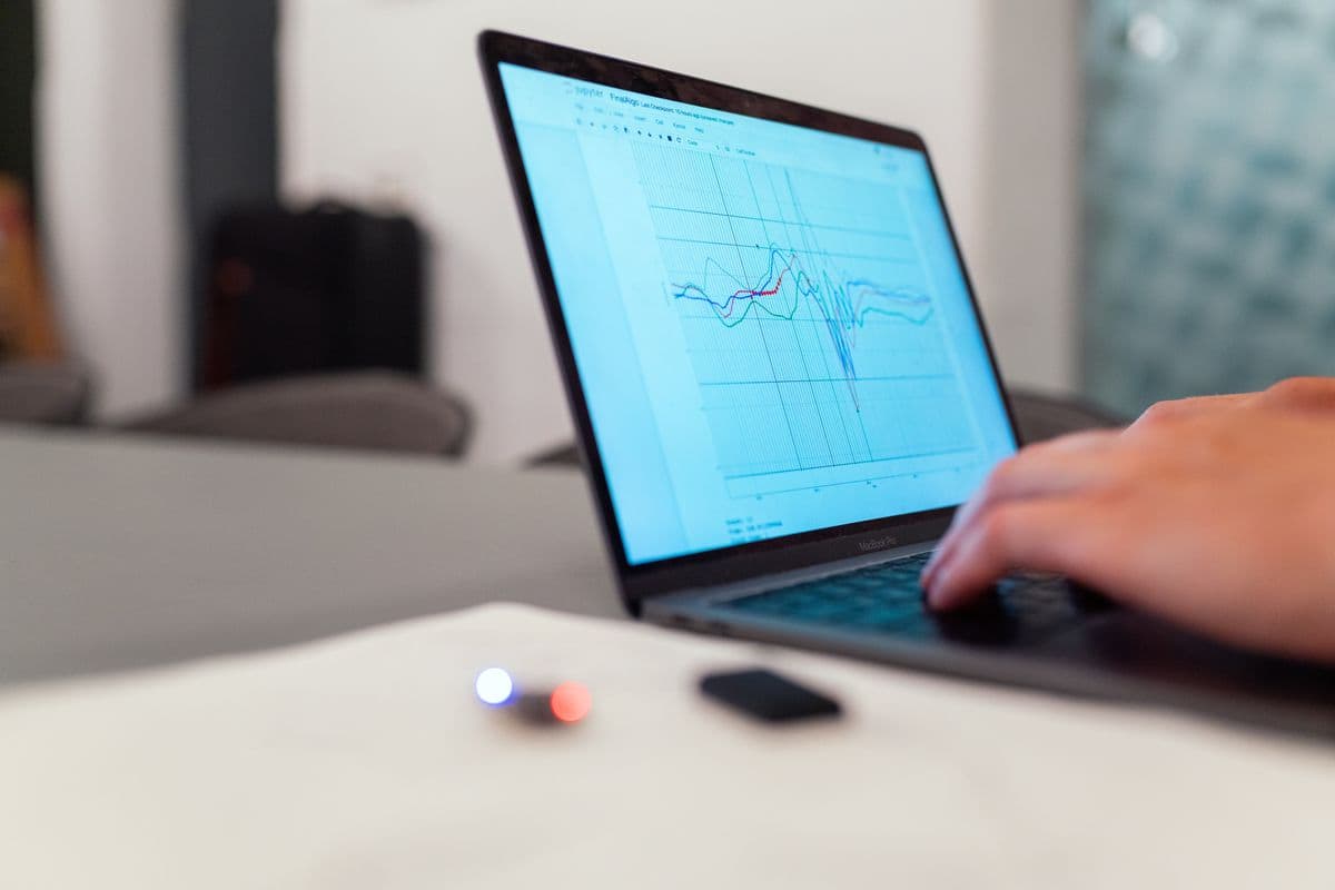 Grafik data pada layar laptop di meja kerja.