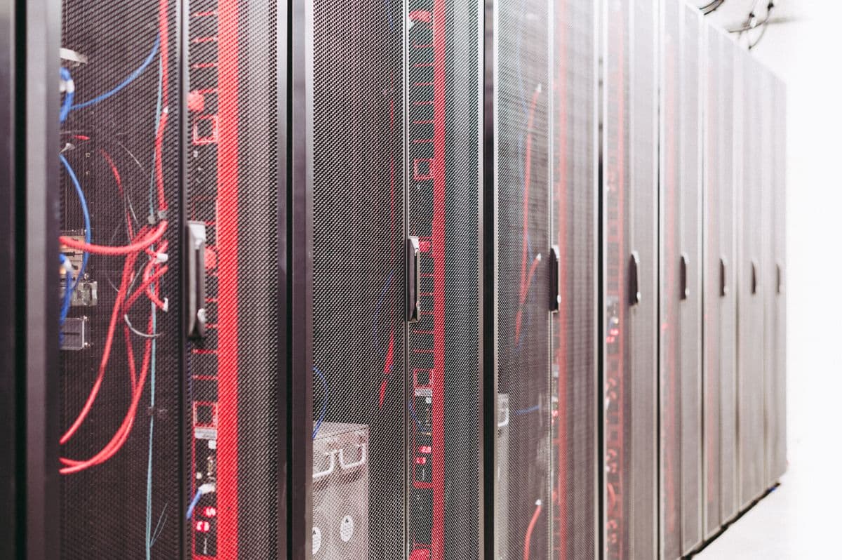 Rak server data center dengan kabel jaringan tersusun rapi di ruang server.