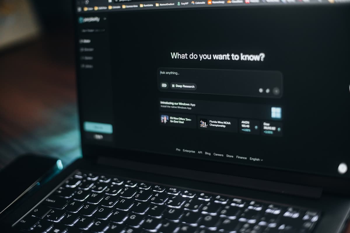 Layar laptop menampilkan kolom pencarian dengan antarmuka bertema kecerdasan buatan.